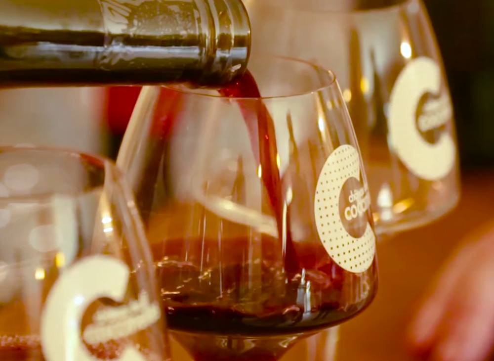 Glass of organic AOP Côtes du Rhône red wine at a free outdoor tasting, Gard